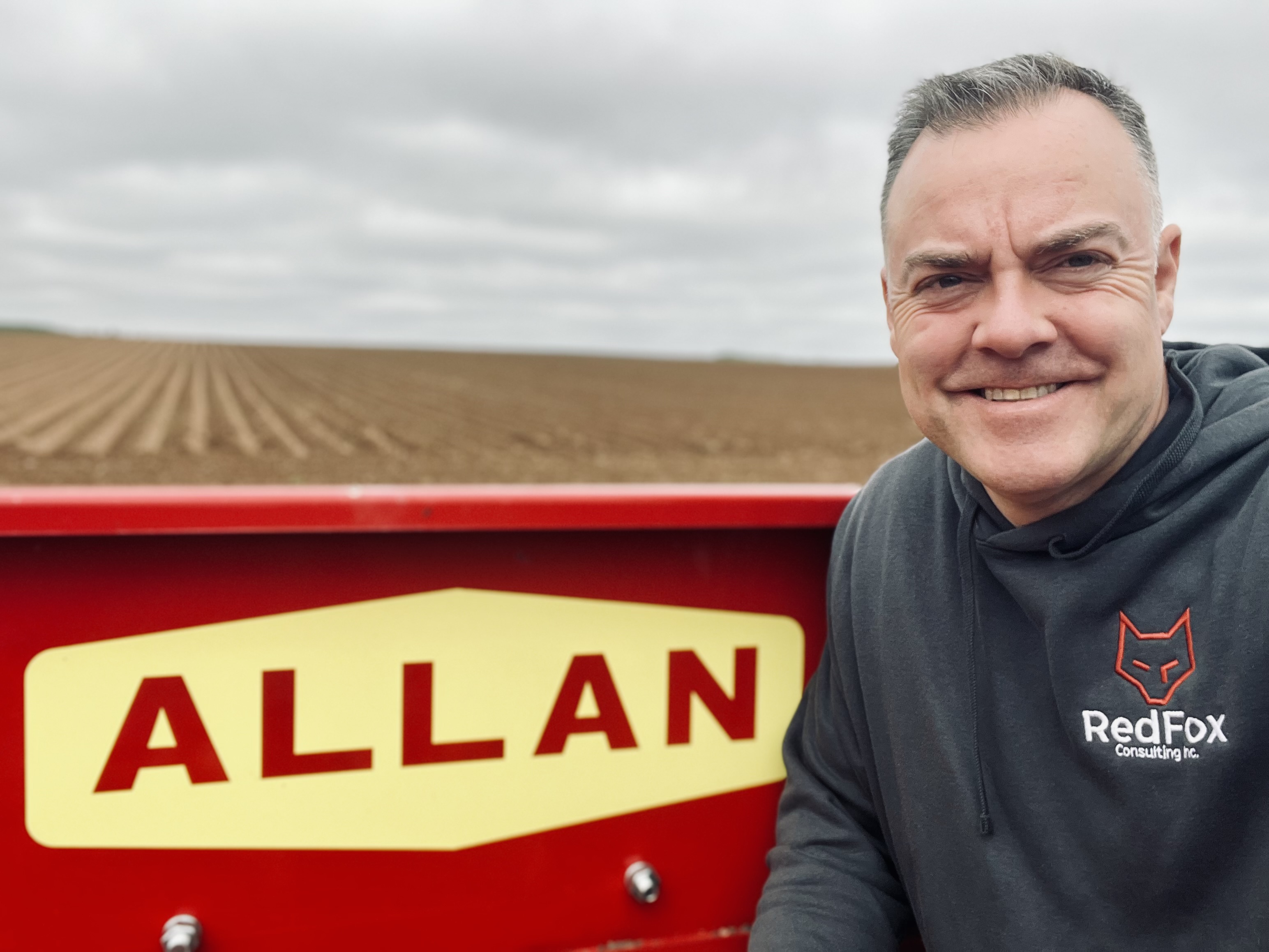 Brian Stewart beside agricultural equipment in a field